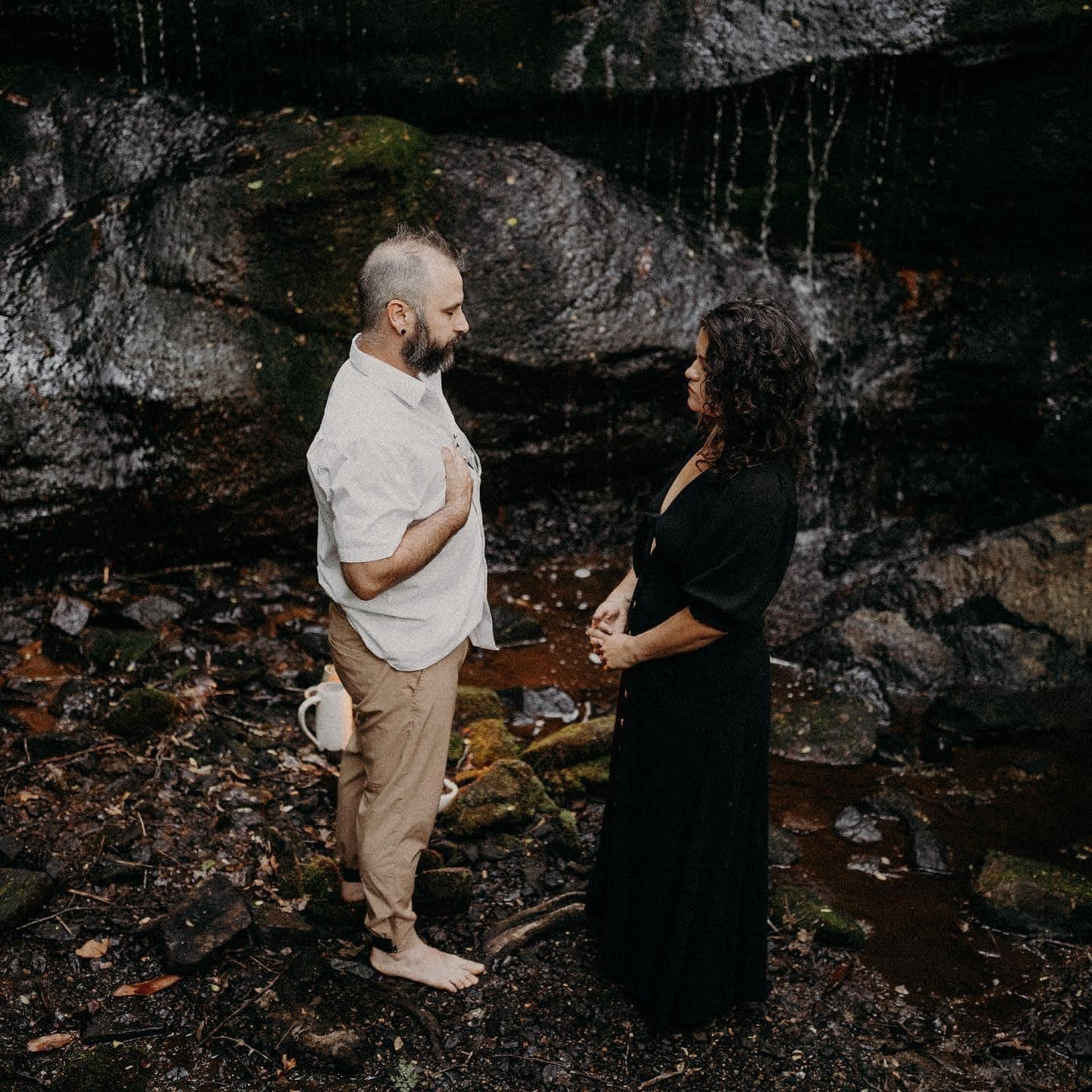 Two people meeting beside a mountain stream